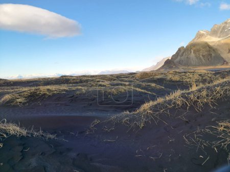 Foto de Región norte con playa de arena negra a lo largo de la costa y montañas congeladas de Vestrahorn en Islandia. Espectacular frente a la playa de Stokksnes con paisajes icelándicos y horizonte ártico natural. - Imagen libre de derechos