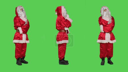 Foto de Padre Navidad piensa en el nuevo plan durante la víspera de Navidad celebración festiva, pantalla verde de cuerpo completo. Saint Nick ideas de lluvia de ideas, mientras que él está usando traje rojo con barba blanca. - Imagen libre de derechos