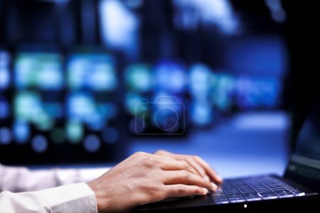 Photo for Close up shot of admin in cloud computing business using laptop to set up configuration management tools that enable automatic failover and load balancing, preventing server racks system crash - Royalty Free Image