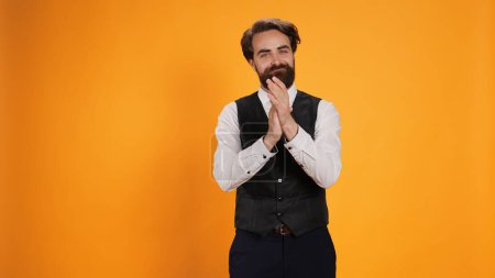 Photo for Positive butler clapping hands on camera, applauding to express congratulations for achievement. Joyful restaurant worker with suit and tie cheering for someone in studio, showing admiration. - Royalty Free Image