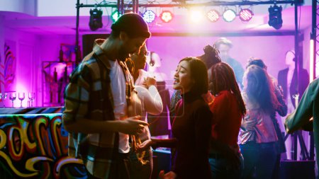 Photo for Happy couples partying at nightclub, enjoying romantic music and dancing in pairs. Dance partners waltzing and having fun with people at celebration event, attending disco party. Handheld shot. - Royalty Free Image
