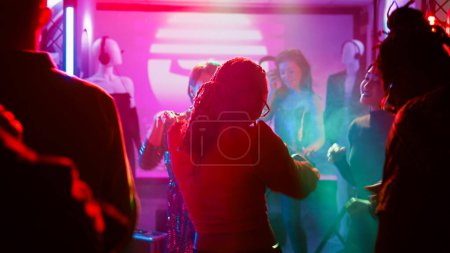Photo for People partying interrupted by police officers, young adults seeing police sirens or lights and stopping the music. Men and women being afraid of law enforcement at nightclub. Handheld shot. - Royalty Free Image