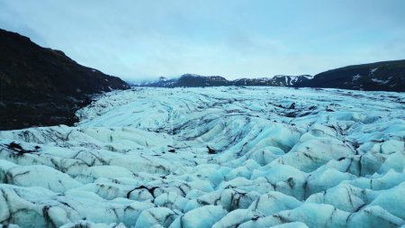 Téléchargez les photos : Spectaculaire glacier vatnajokull flottant autour des eaux glacées, de beaux blocs de glace de couleur bleue et verte. Drone de route panoramique avec des roches glacées et des icebergs. Mouvement lent. - en image libre de droit