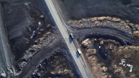 Téléchargez les photos : Paysage arctique en iceland, beaux champs de glace et routes à la campagne. Terres noires gelées naturelles avec de la neige formant des paysages scandinaves. Un drone. Vue aérienne. - en image libre de droit