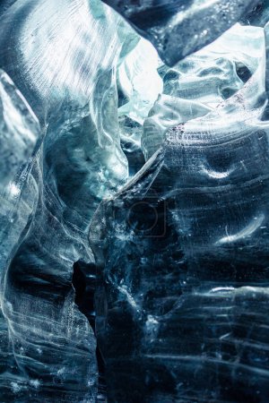 Foto de Dentro de cuevas de iceberg vatnajokull con estructura agrietada de bloques de hielo, paisaje nórdico icelandés. Enorme glaciar transparente en invernal frío paisaje, rocas heladas en grieta. - Imagen libre de derechos
