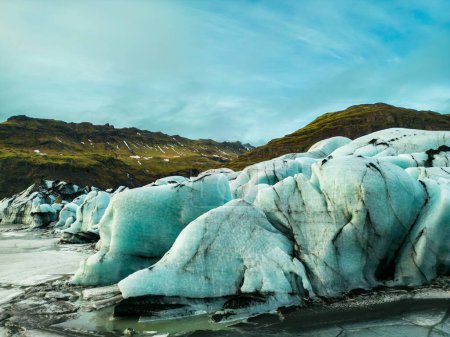 Foto de Vista aérea de la masa glaciar vatnajokull, fantástica laguna glaciar azul que se forma en el lago congelado en la región icelándica. Espectacular icebergs nórdicos y bloques de hielo glaciales agrietados en tierra helada. - Imagen libre de derechos