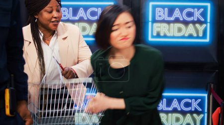 Aggressive clients start fight in store, black friday madness. People obsessed with shopping during seasonal sales event acting crazy after entering shopping center, crowd control.