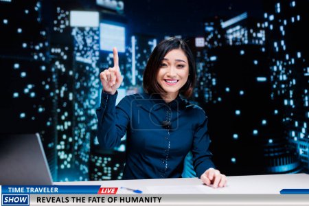 Photo for Newscaster talks about time traveler on television program, hosting night show to present secrets of humanity from future. Asian journalist addressing news about peoples fate. - Royalty Free Image