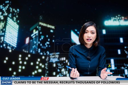 Photo for Disturbing news about cult leader recruiting followers by brainwashing them into thinking he is messiah, events presented by tv reporter. Woman night show host reading headlines. - Royalty Free Image
