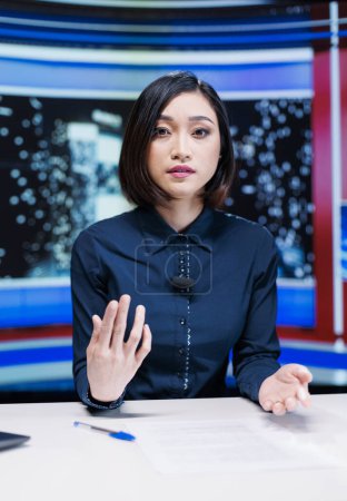 Photo for Journalist on late night show hosting entertainment and media segment using headlines to present breaking news. Woman presenter discussing about international reportage with exclusive details. - Royalty Free Image