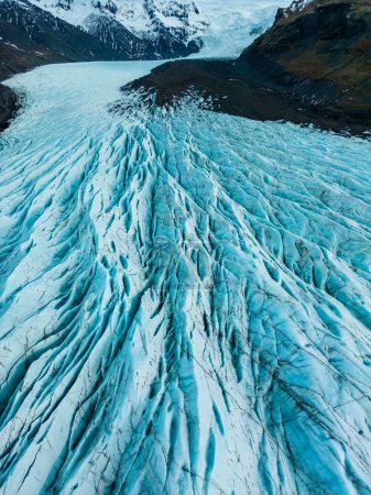 Téléchargez les photos : Vue aérienne de la calotte glaciaire sur la région hivernale, blocs massifs de glace fissurée avec crevasses dans la banquise. Des roches spectaculaires en forme de diamant bleu créent des paysages nordiques, des icebergs gelés couverts. - en image libre de droit