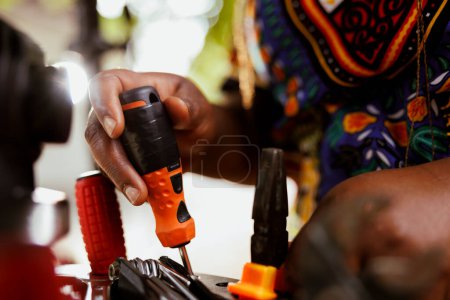Photo for Closeup shot of african american hands grasping bicycle tools from professional toolbox for maintenance and repairs. Detailed image of individual arranging specialized equipments. - Royalty Free Image