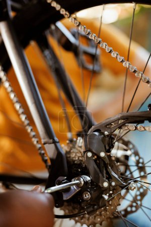 Photo for Close up of person using expert work tools to adjust and secure bike pedals and chain ring. Detailed shot of black female arm fixing bicycle component with allen key for yearly maintenance. - Royalty Free Image