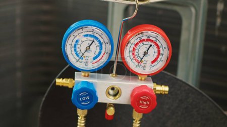 Photo for Close up shot of professional ac gauges vacuum pump used for checking HVAC system freon. Set of manometers showing high or low refrigerant levels in external air conditioner - Royalty Free Image