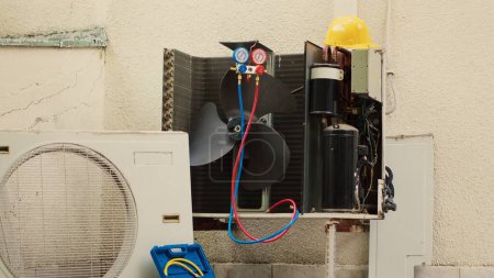 Vergrößern Sie die Aufnahme eines beschädigten externen Luftkühlgeräts mit einer reparaturbedürftigen Schutzhülle mit defekten Innenteilen. Außenkondensator nicht mehr funktionsfähig, reparaturbereit