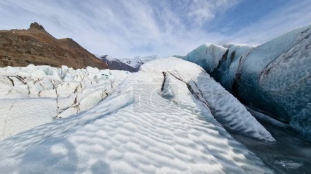 Téléchargez les photos : L'iceberg de Vatnajokull a fissuré la masse de glace dans la banquise, des blocs de glace magiques avec d'énormes grottes et tunnels autour des falaises enneigées et du paysage. Lagune glaciaire gelée avec fragments de glace, lac froid gelé. - en image libre de droit