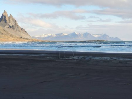 Téléchargez les photos : Magnifique emplacement naturel sur la péninsule de Stokksnes avec des falaises rocheuses du vestrahorn et une plage de sable noir. Pentes massives et rivage incroyable en Islande, scène paradisiaque avec la côte de l'océan. - en image libre de droit