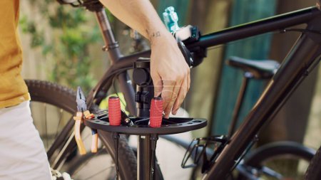 Photo for Detailed shot of caucasian person choosing specialized work tools for outdoor bike maintenance. Close-up view of hands holding and arranging various equipment for modern bicycle repair. - Royalty Free Image