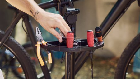 Gros plan sur les outils finement ajustés qui sont soigneusement disposés sur le stand de réparation en attendant que des activités d'entretien des vélos aient lieu. Équipement d'organisation de l'homme pour l'entretien du vélo.