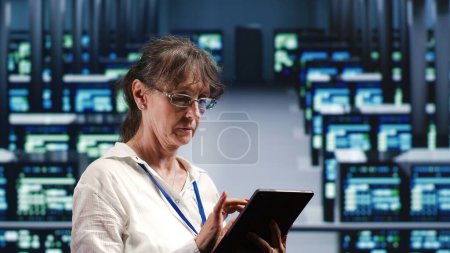 Mujer meticulosa de soporte técnico en centro de datos equipada para manejar operaciones informáticas complejas, haciendo actualizaciones regulares a los componentes del servidor, aumentando la potencia de procesamiento para evitar accidentes