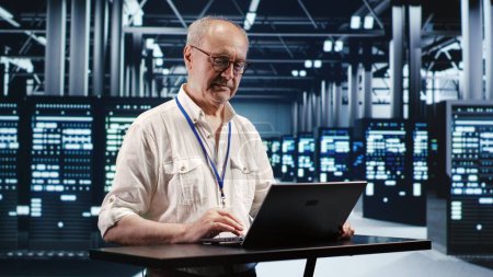 Skilled IT professional expertly managing data while navigating in industrial server room. Expert ensuring flawless cybersecurity protection, optimizing systems and performing necessary updates