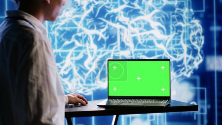 Professionelle Arbeiter, die Green Screen Laptop verwenden, um künstliche Intelligenz parallel zu verarbeiten. Technische Unterstützung Mann arbeitet an Chroma-Schlüssel-Gerät ermöglicht KI-Systeme maschinelles Lernen Schlussfolgerung zu tun
