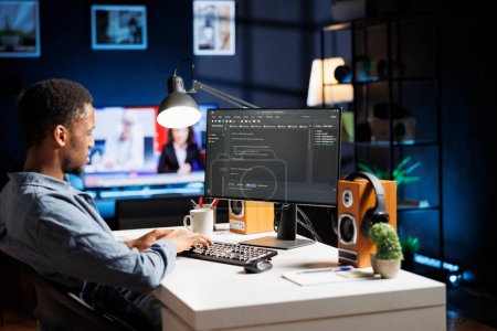 Systemingenieur tippt Skriptcode für Sicherheit und Schutz ein und arbeitet zu Hause mit Programmiersprache. Afrikanisch-amerikanischer Entwickler Codierung und Debugging-Server auf Terminal-Fenster.