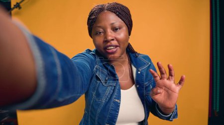 El video captura a una mujer afroamericana con comportamiento positivo, elaborando sobre la profesión de mensajera. Joven mujer negra en bicicleta habla sobre el servicio de entrega de comida mientras mira directamente a la cámara.