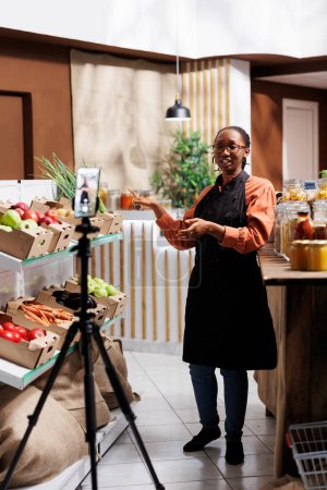 African American owner of sustainable shop promotes fresh, local and organic products. Filming with a cell phone, she creates engaging content for online marketing and social media promotion.