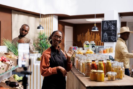 African American business owner promoting fresh, organic products in a modern, eco friendly store. Customers browse and buy while capturing attention through social media and online marketing.