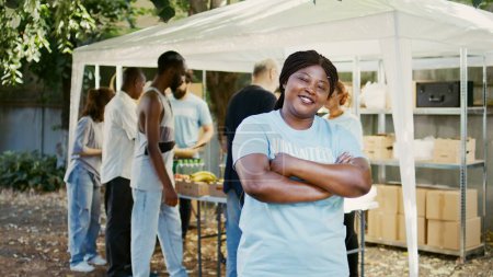 Foto de Las mujeres voluntarias afroamericanas sonríen y posan durante un evento benéfico de comida. Programa de ayuda humanitaria que alivia el hambre y ayuda a las personas sin hogar y a los pobres. Retrato plano. - Imagen libre de derechos