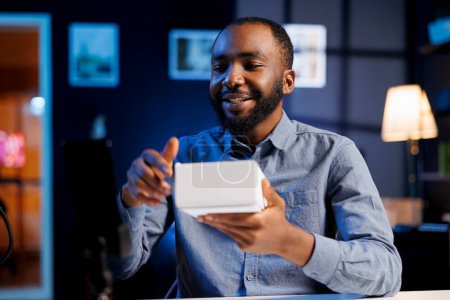 African american online show host being sponsored by partnering brand to do unboxing video on streaming platform. BIPOC man does influencer marketing, presenting viewers product advertisement