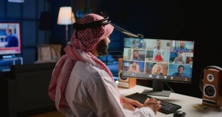 Photo for Remote Middle Eastern professional holding q and a session with webinar participants via video conference meeting. Muslim Internet video call host engaging in online discussions with trainees - Royalty Free Image