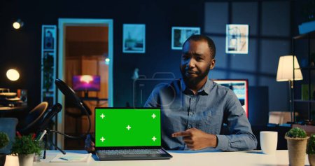 Tech-Medienstar filmt Chroma Key Laptop beim Auspacken und gibt Gründe für den Kauf an. Influencer erfassen Video drängt Abonnenten, Sponsoring-Partner kaufen isolierte Bildschirm-Notebook