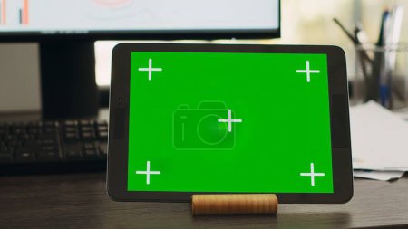 Photo for Empty desk with greenscreen on tablet in business coworking space, isolated copyspace layout on modern gadget display. Workstation with device showing chromakey mockup screen. - Royalty Free Image