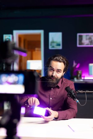 Spécialiste technique en studio filmant examen de la technologie de mini lumières LED à l'aide d'une caméra professionnelle. Éditeur vidéo montrant l'équipement de tournage aux abonnés, enregistrement avec des appareils spécialisés
