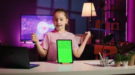 Kinder Internet Show Host Werbung Green Screen Tablette von Sponsoring-Marke erhalten. Junger Kinderstar macht Influencer-Marketing und drängt Follower zum Kauf von Chroma-Schlüsselgerät