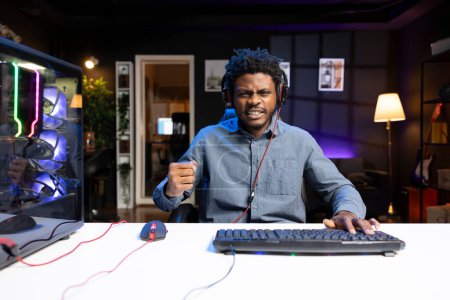 Excited gamer feeling happy after winning PC game during live stream with viewers. Delighted player bragging after being victorious in videogame while broadcasting gameplay for audience