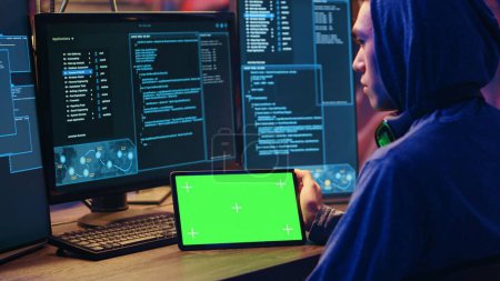 Photo for Hackers doing computer sabotage using encryption trojan ransomware on green screen tablet. Cybercriminals use mockup device to demand ransom money from victims in exchange for access to their data - Royalty Free Image