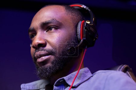 Close up of pro man streaming videogame on powerful computer during online gaming championship, talking into headset. Gamer taking part in Esport team of gamers, competing in game