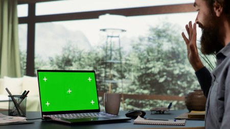 Photo for Rich businessman looks at greenscreen on pc, being cozy in his luxurious villa in the woods. Shareholder of multinational company logs onto laptop with isolated chromakey, billionaire lifestyle. - Royalty Free Image