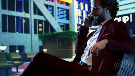 Photo for Banking advisor chatting on phone call with company CEO, sitting on a bench in front of skyscraper building downtown. Businessperson trying to obtain new investment funds from shareholders. - Royalty Free Image
