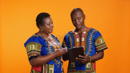 Photo for African american couple buying clothes on sale with web payment, enjoying online shopping session using tablet. Young married people looking for items on store website or app, mobile gadget. - Royalty Free Image