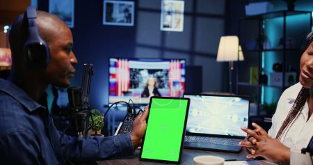 Isolated screen tablet in front of show host recording podcast, enjoying nice conversation with happy guest. Chroma key device in professional studio used for podcasting live session with woman
