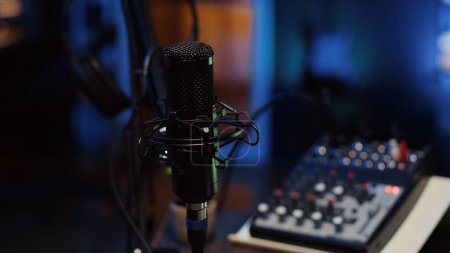 Foto de Primer plano de micrófono profesional utilizado para grabar conversaciones de podcast para canal de transmisión en vivo en línea. Equipo de captura y grabación de sonido de alta calidad en el estudio de apartamentos - Imagen libre de derechos