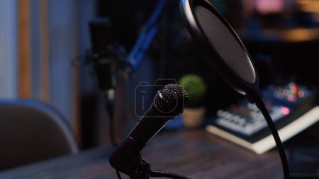 Téléchargez les photos : Zoom arrière prise de vue du microphone podcast utilisé pour enregistrer des conversations avec une qualité sonore impeccable pour l'émission Internet. Gros plan sur la technologie de capture et d'enregistrement audio - en image libre de droit