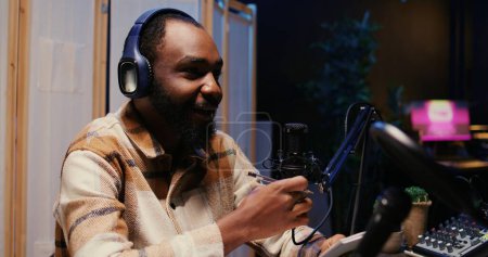 Zoom in on african american man on podcast discussing with guest during marathon stream for humanitarian cause. Host chatting with celebrity, gathering donations from audience during internet show