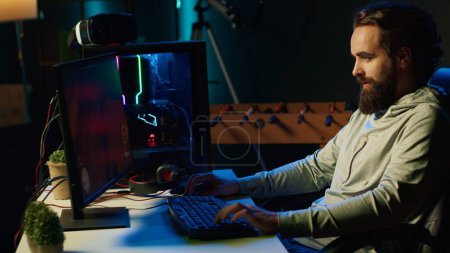 Photo for Man playing science fiction FPS videogame, having fun in dark apartment room. Gamer competing in PvP online multiplayer game, shooting other players with futuristic gun laser bullets - Royalty Free Image