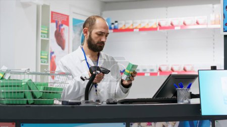 Photo for Medical retail clerk scanning supplies to register new stock, working at drugstore checkout counter to ensure medicaments and vitamins inventory. Pharmacist using scanner on pharmaceutics in shop. - Royalty Free Image