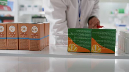 Ein Apotheker holt Vitaminboxen aus den Regalen und ersetzt sie durch andere Medikamente. Mitarbeiter sortieren pharmazeutische Produkte in Gesundheitseinrichtungen um. Stativschuss.